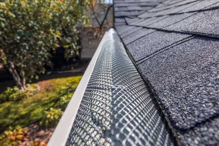 A contractor demonstrating the effectiveness of a gutter guard to a potential client in Oregon City